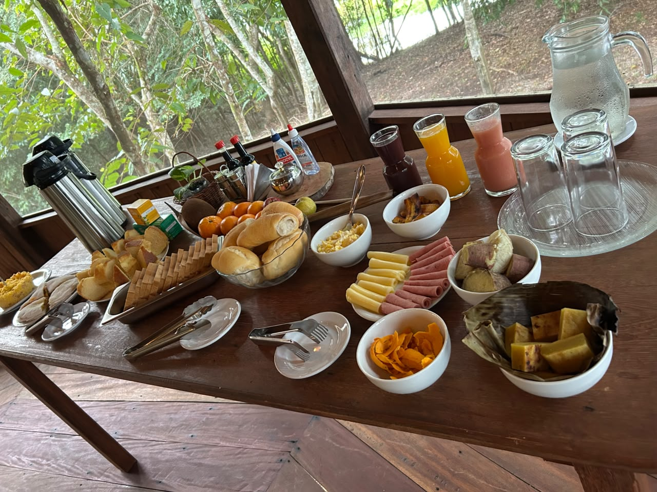 Breakfast table with bread, fruit, juices, coffee and regional sides.